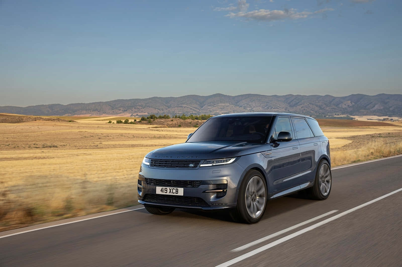 The Range Rover Evoque Is Driving Down A Country Road