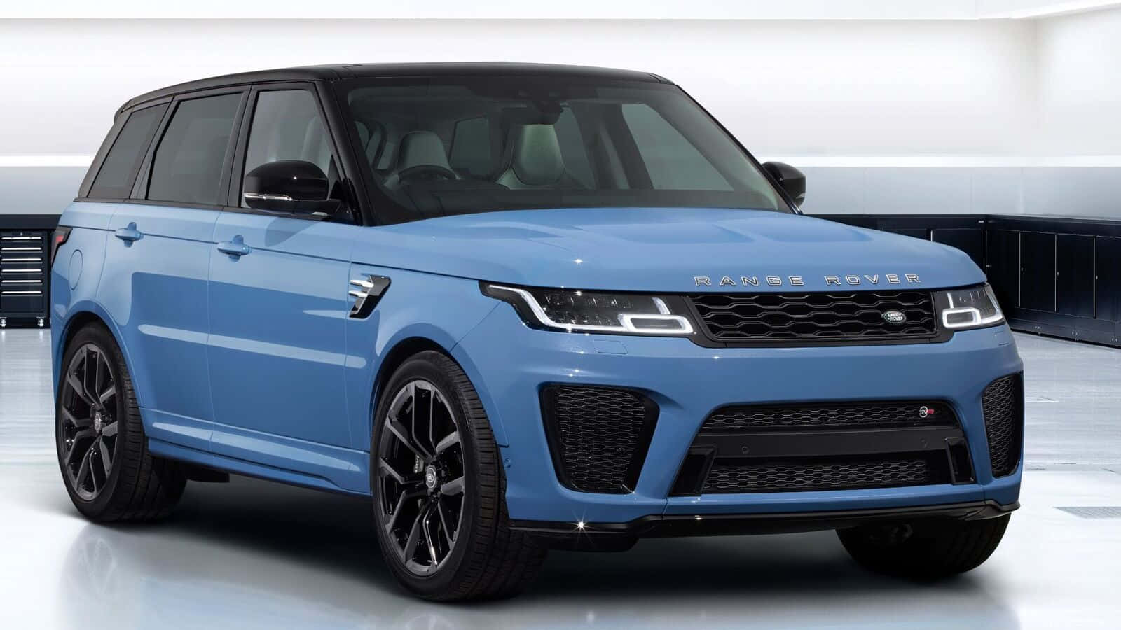The Blue Land Rover Rover Sport Is Shown In A Garage