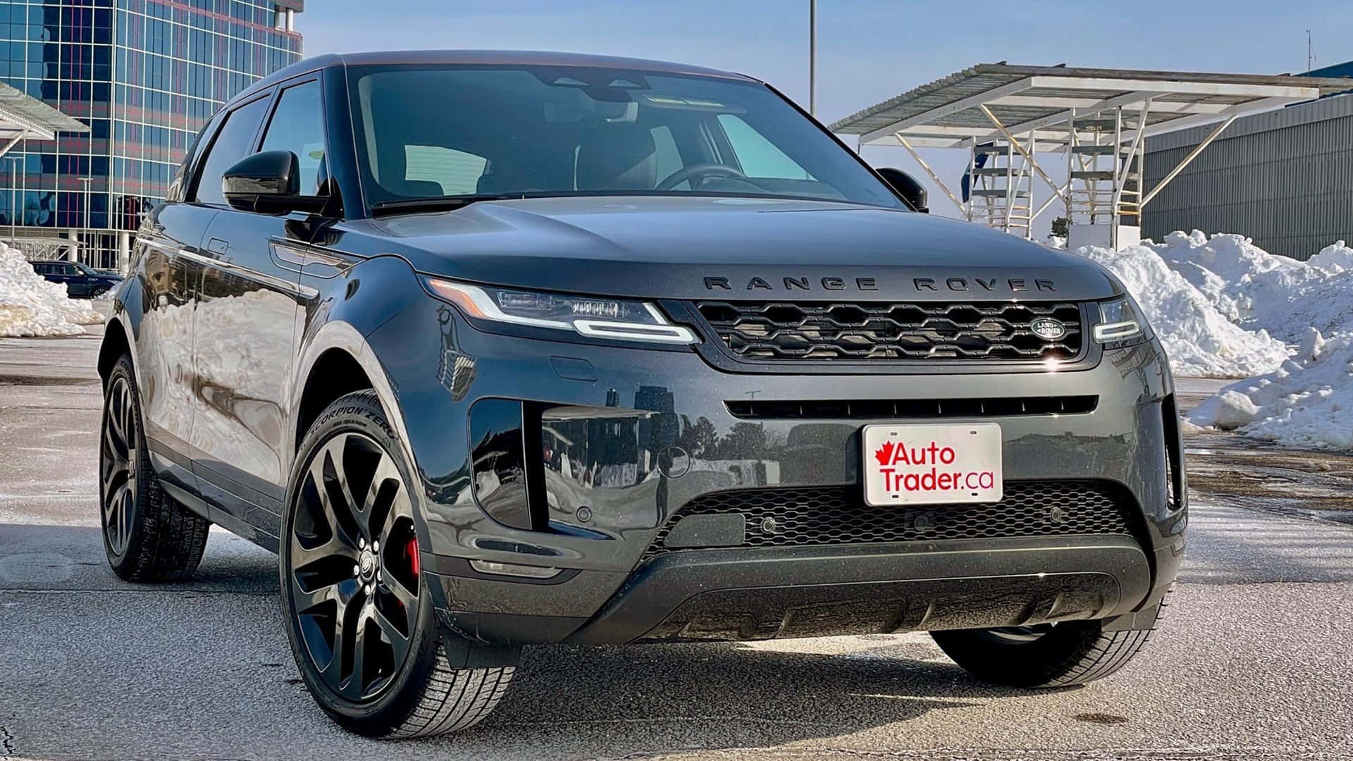 Larange Rover Evoque 2019 È Parcheggiata Davanti A Un Edificio.