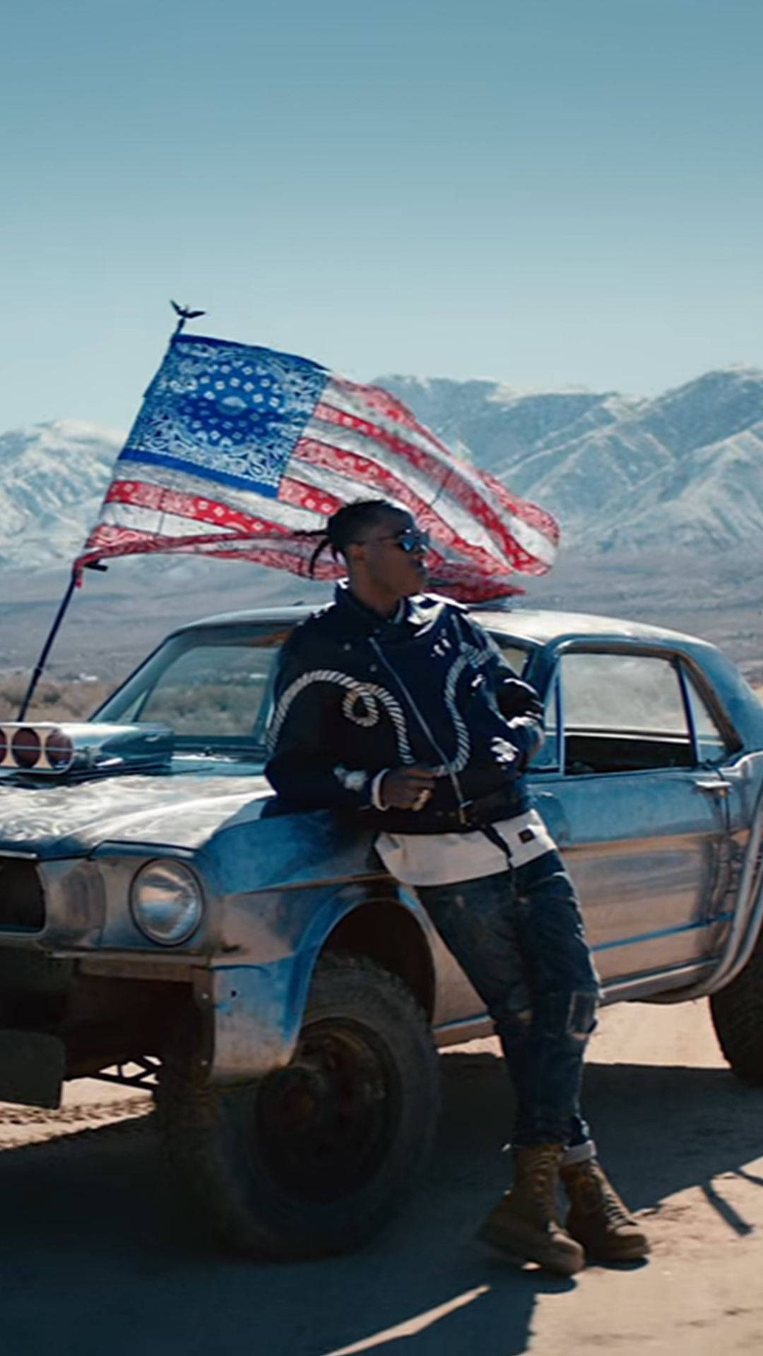 Enman Står Bredvid En Blå Bil Med Amerikansk Flagga. Wallpaper