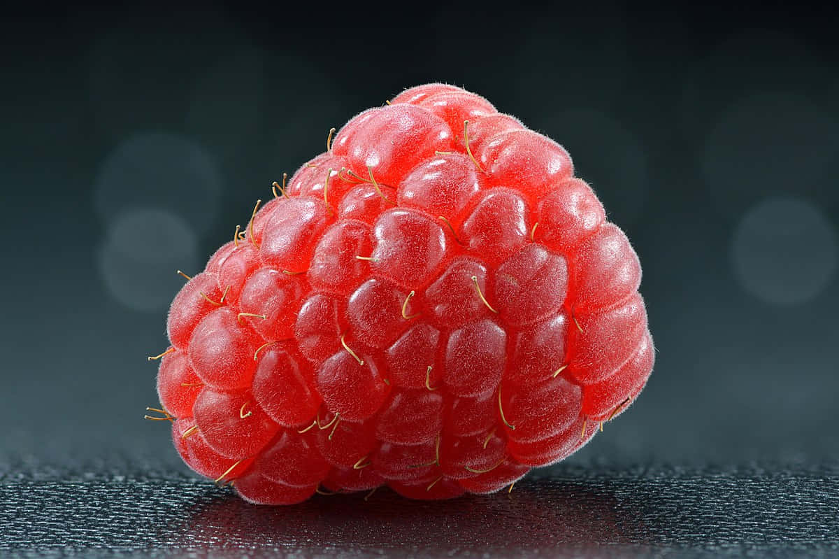 A Red Raspberry On A Black Background