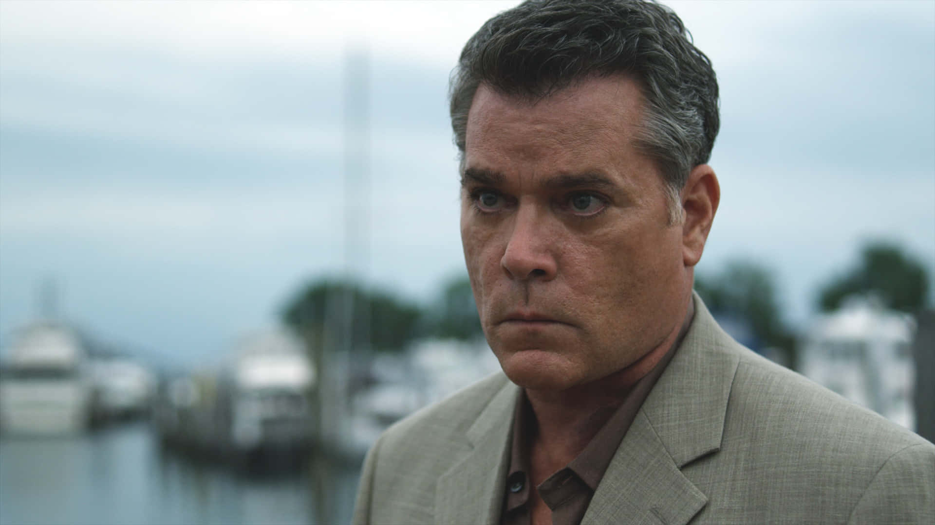 Ray Liotta looking seriously while donning a sleek black suit Wallpaper