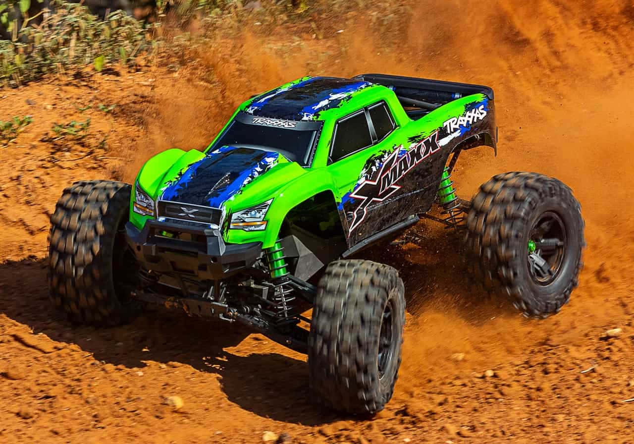 A Green Monster Truck Is Driving Through A Dirt Field