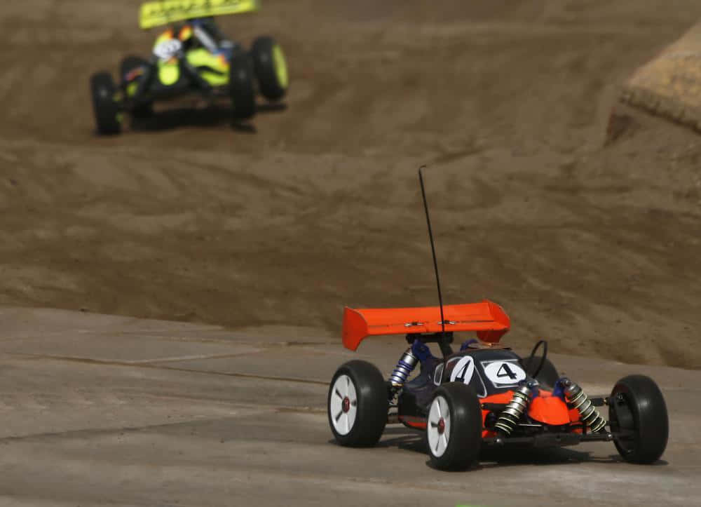 A Toy Car Is Driving Down A Dirt Track