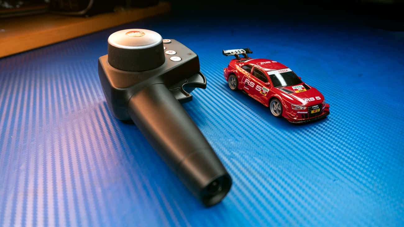 A Toy Car And A Remote Control Car On A Blue Surface