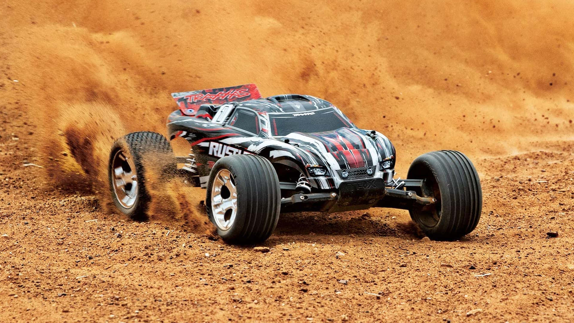 A Remote Control Car Driving On A Dirt Field