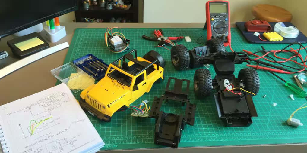 A Desk With A Toy Car And Other Electronics