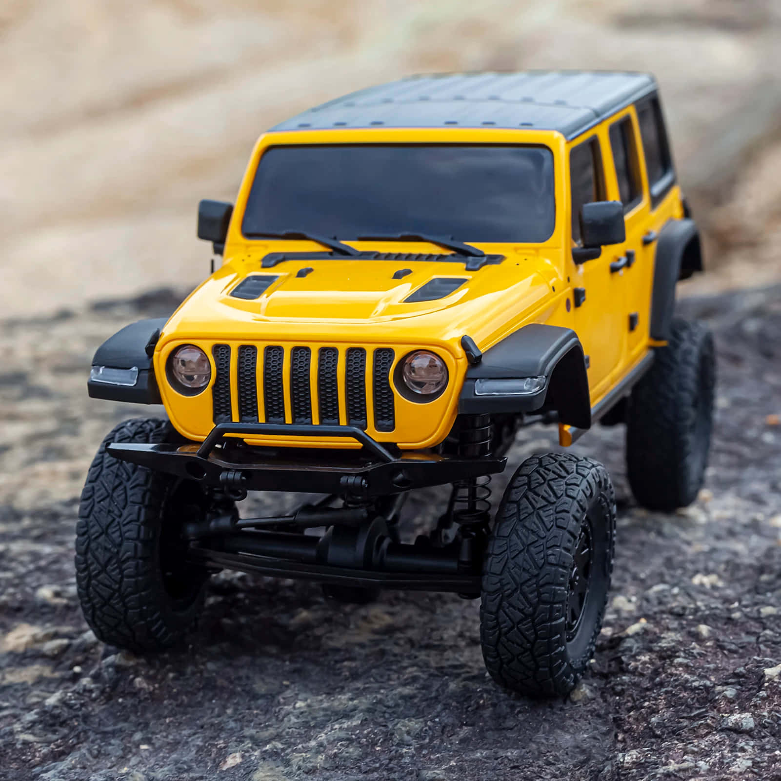 A Yellow Jeep Is Sitting On A Rock
