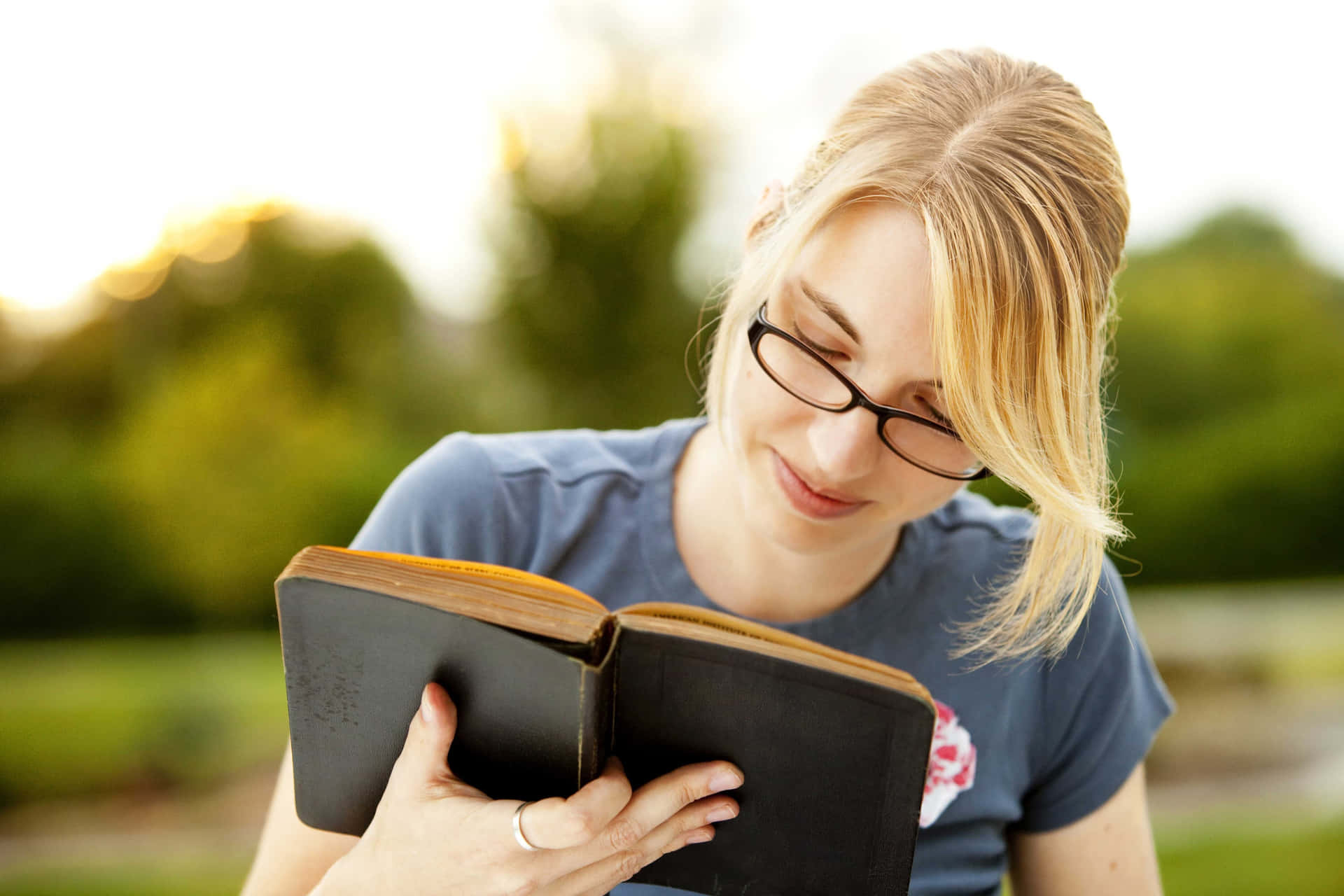 Enkvinde Iført Briller Læser En Bog.