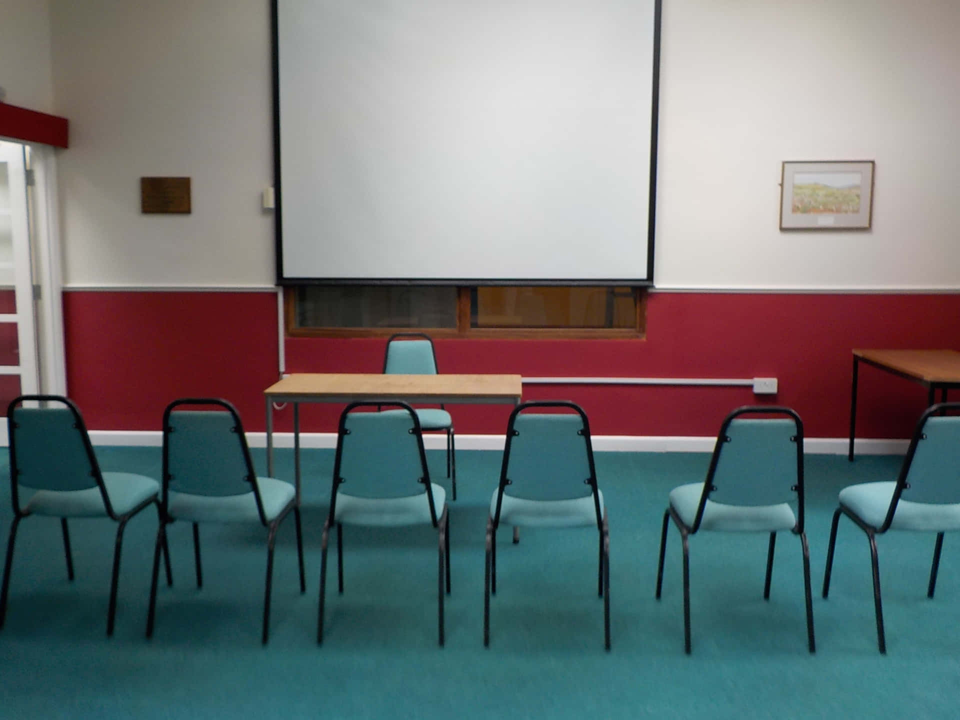 A Room With Chairs And A Projector Screen