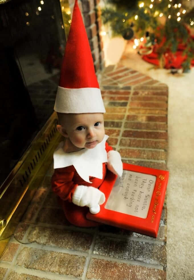 A Baby Dressed As An Elf Reading A Book