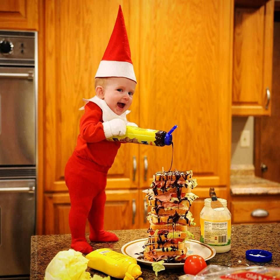 A Baby Dressed As An Elf Is Standing On A Counter