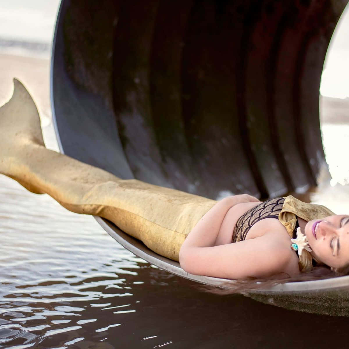 Жена, лежаща върху опашка от русалка във водния тапет