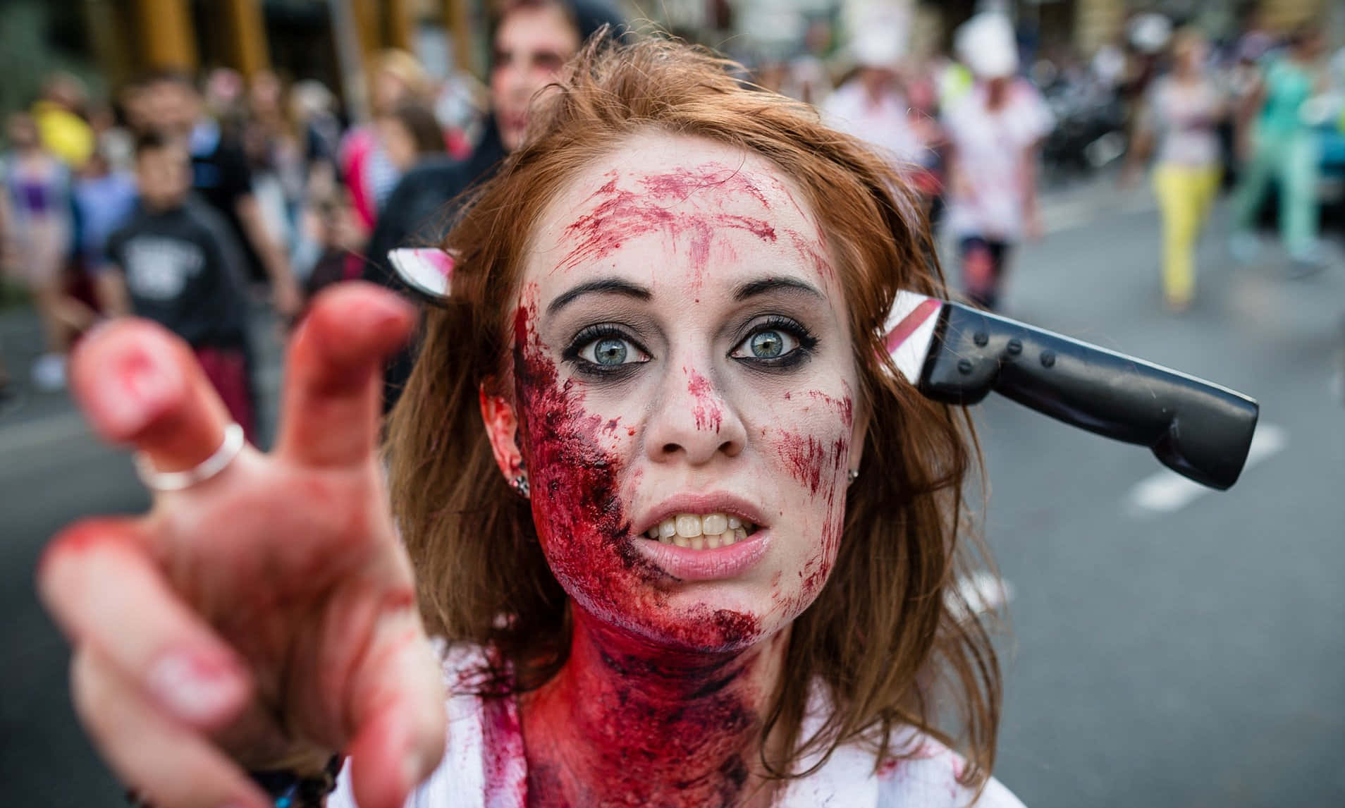a woman dressed as a zombie is holding a knife