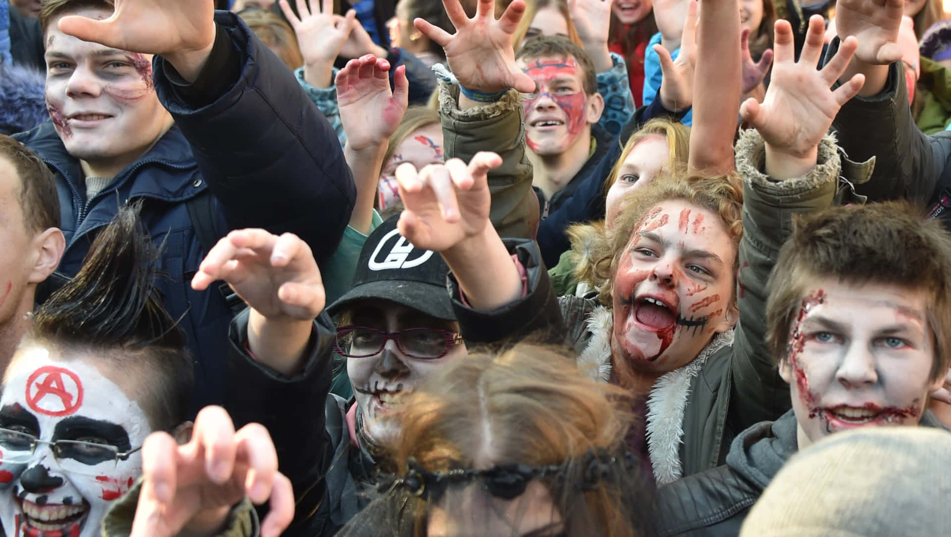 a group of people with zombie makeup and hands up