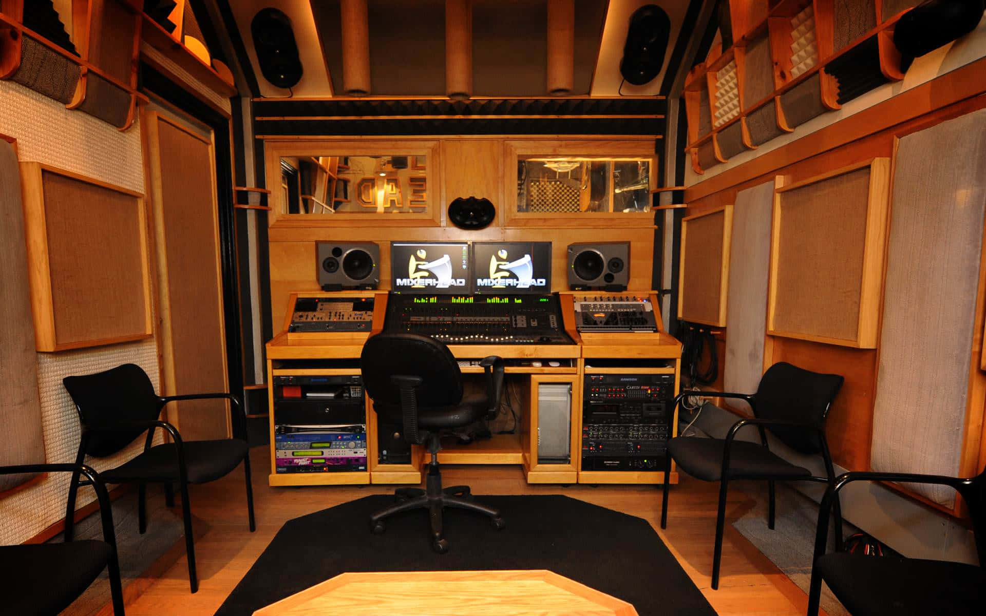 A Recording Studio With A Desk And Chairs