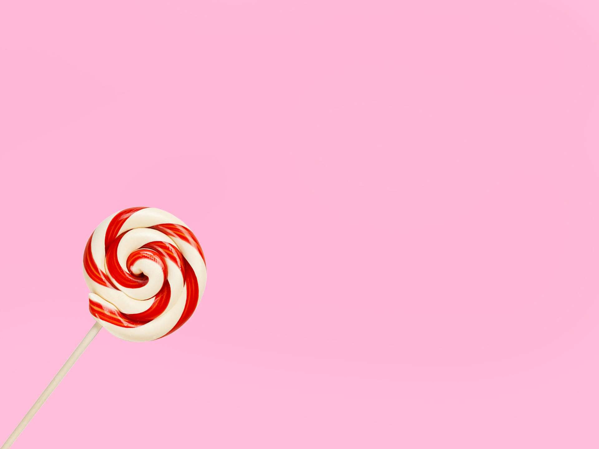 Rød og hvid lollipop på pink baggrund Wallpaper