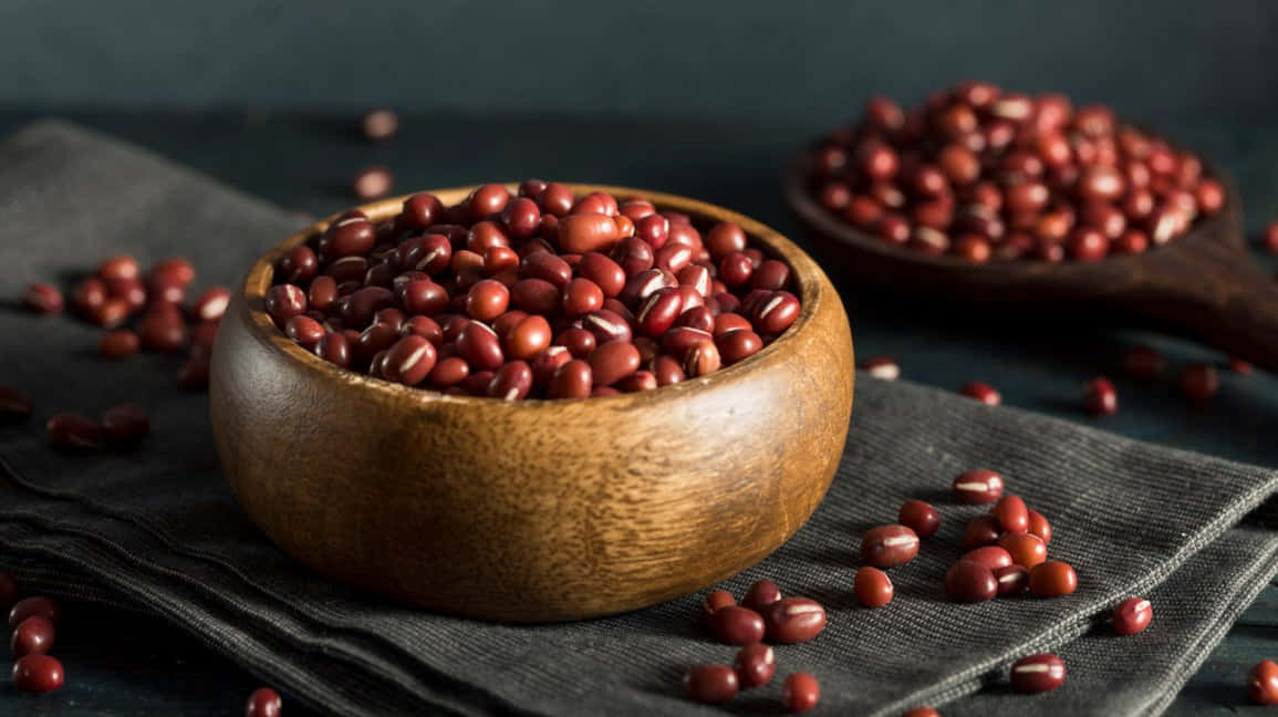 A delicious bowl of red beans on a wooden table Wallpaper