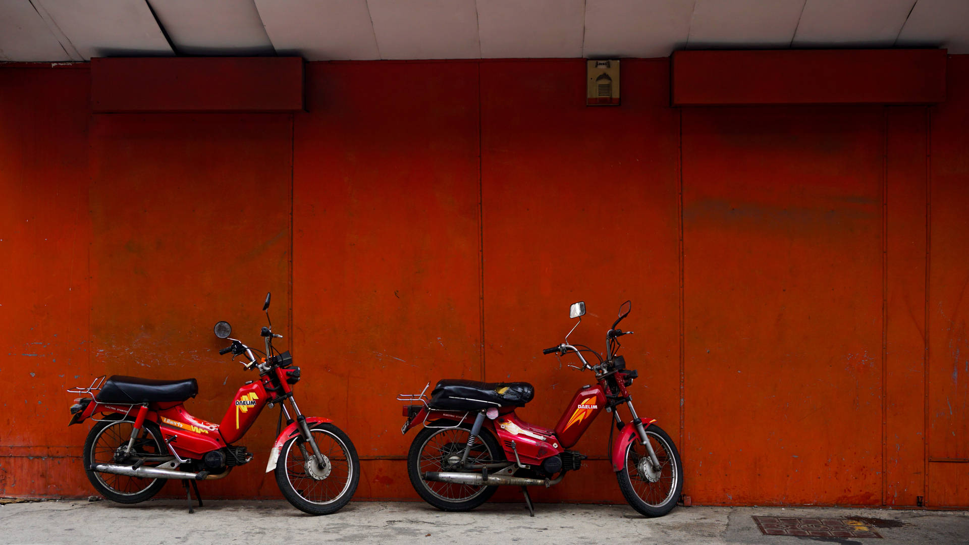 Caption: Sleek Red Bike in an Urban Setting Wallpaper