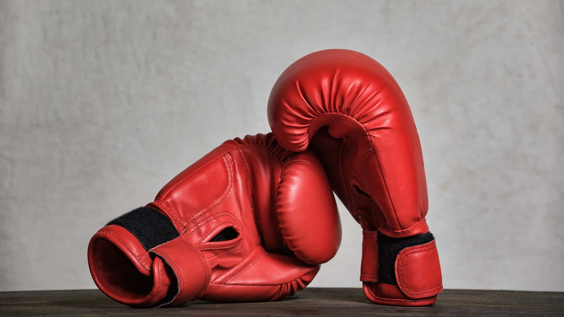 Red Boxing Gloves Restingon Wooden Surface Wallpaper