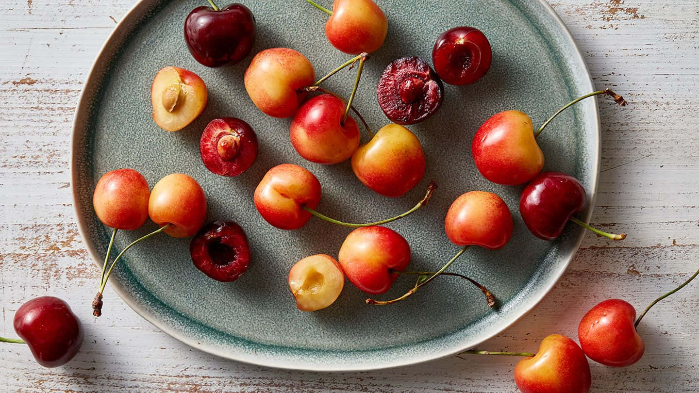 Cerezasrojas Frescas En Una Rama. Fondo de pantalla