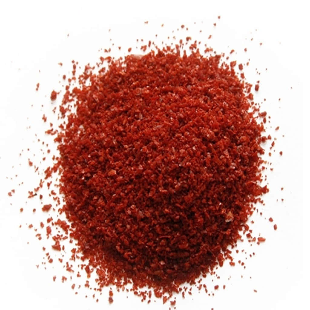 Vibrant Red Chili Powder Displayed on a Wooden Spoon Wallpaper