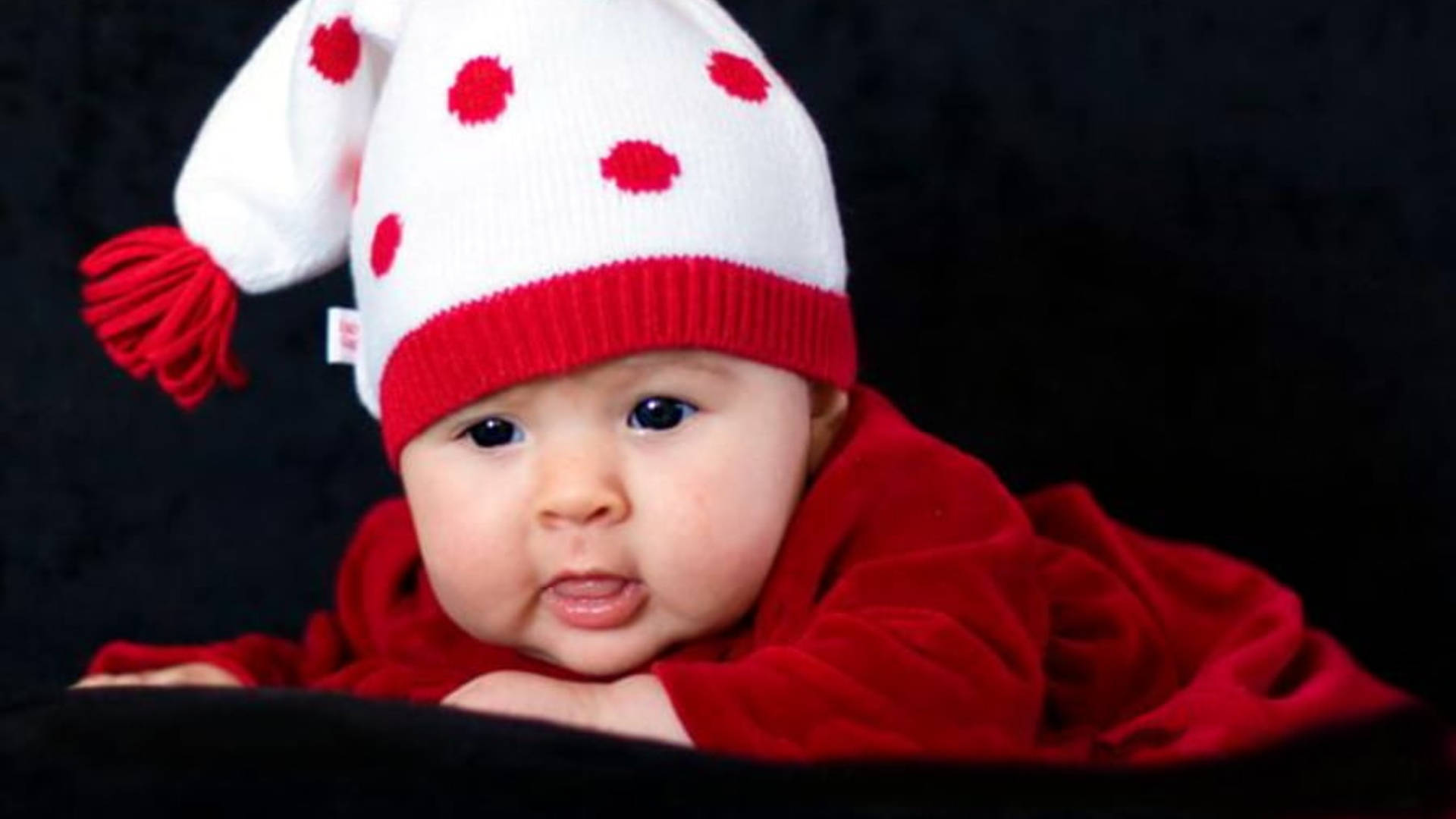 Adorable Baby in Red Outfit Expressing Love Wallpaper