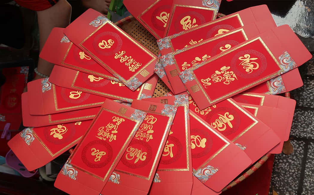 Red envelope in a hand against blurry background Wallpaper