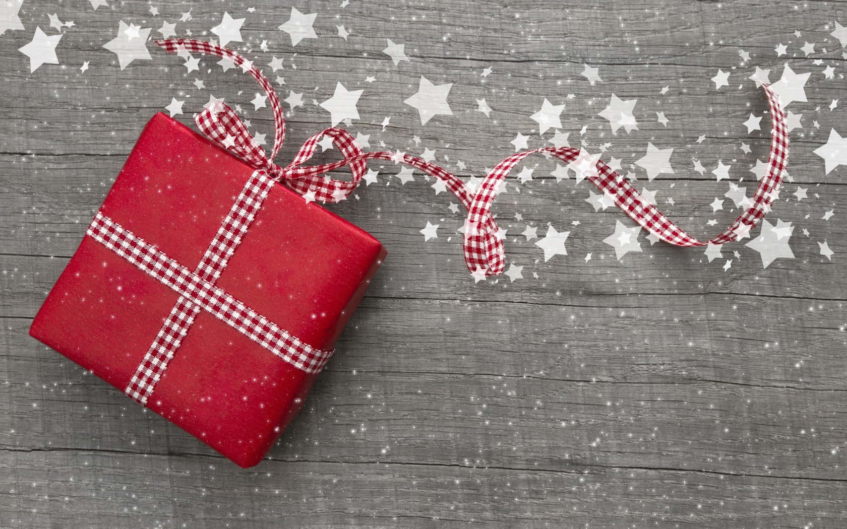 A charming red gift box adorned with twinkling cute stars. Wallpaper