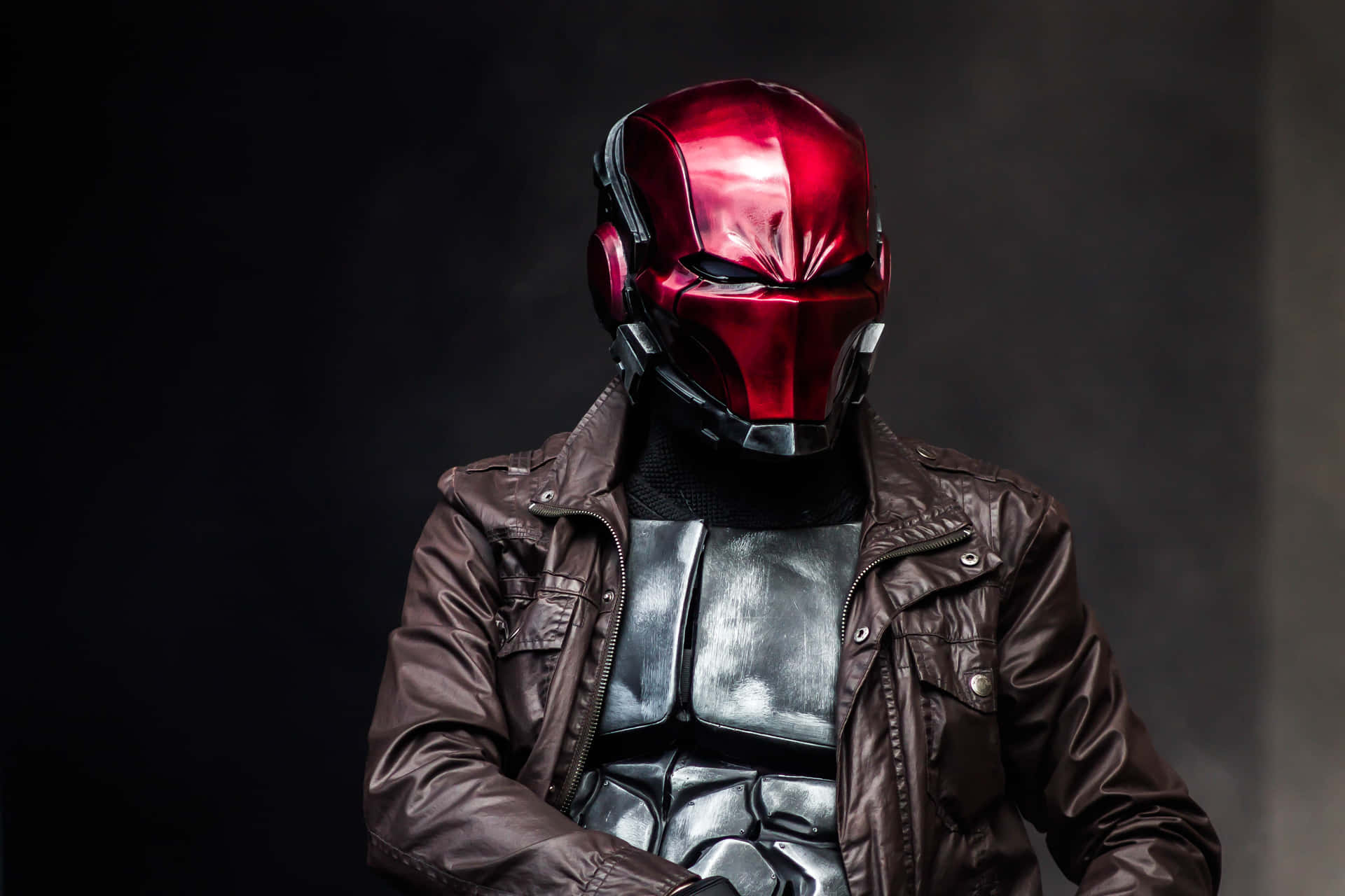 A dark silhouette against a burning sky, Red Hood stands tall, ready to face whatever lies ahead.