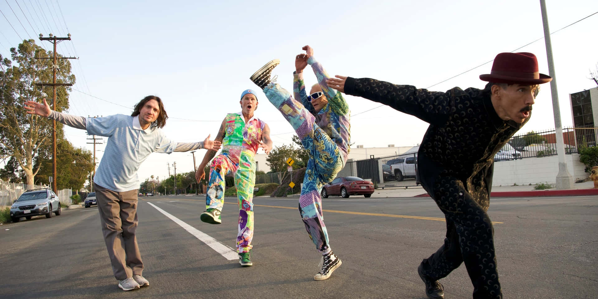 En gruppe mennesker i farverige tøj er at udføre et stunt over en by Wallpaper