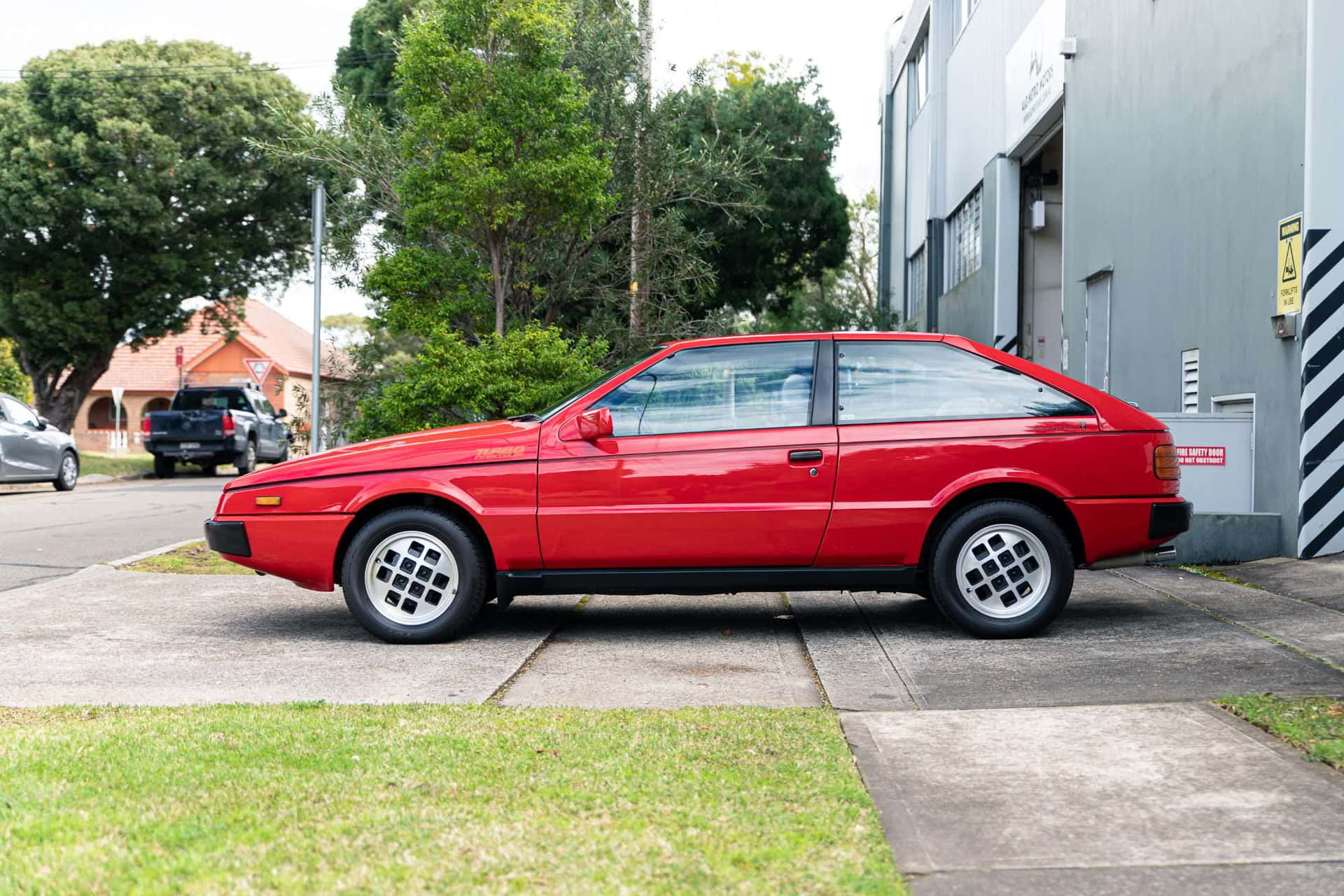 Rode Isuzu Impulse Geparkeerd Op Straat Achtergrond