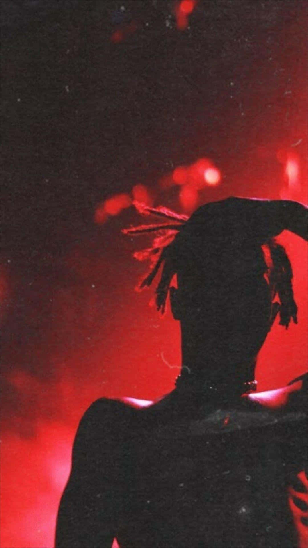 A Silhouette Of A Man With Dreadlocks In The Red Light Wallpaper