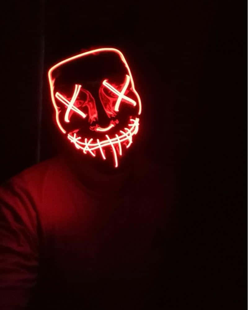 En person iført et rødt LED-maske i mørket. Wallpaper