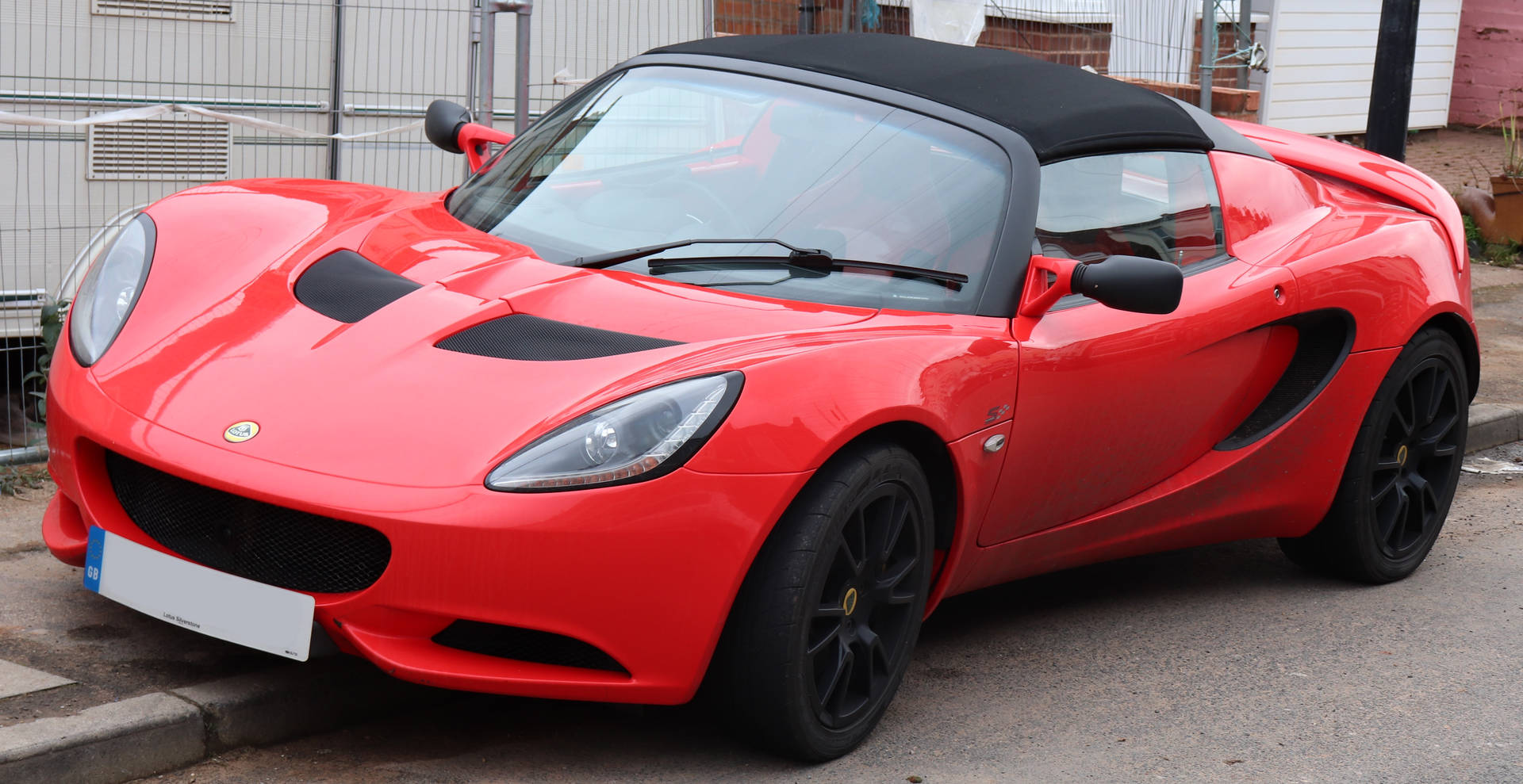 Red Lotus Elise Car Parked On Curb Wallpaper
