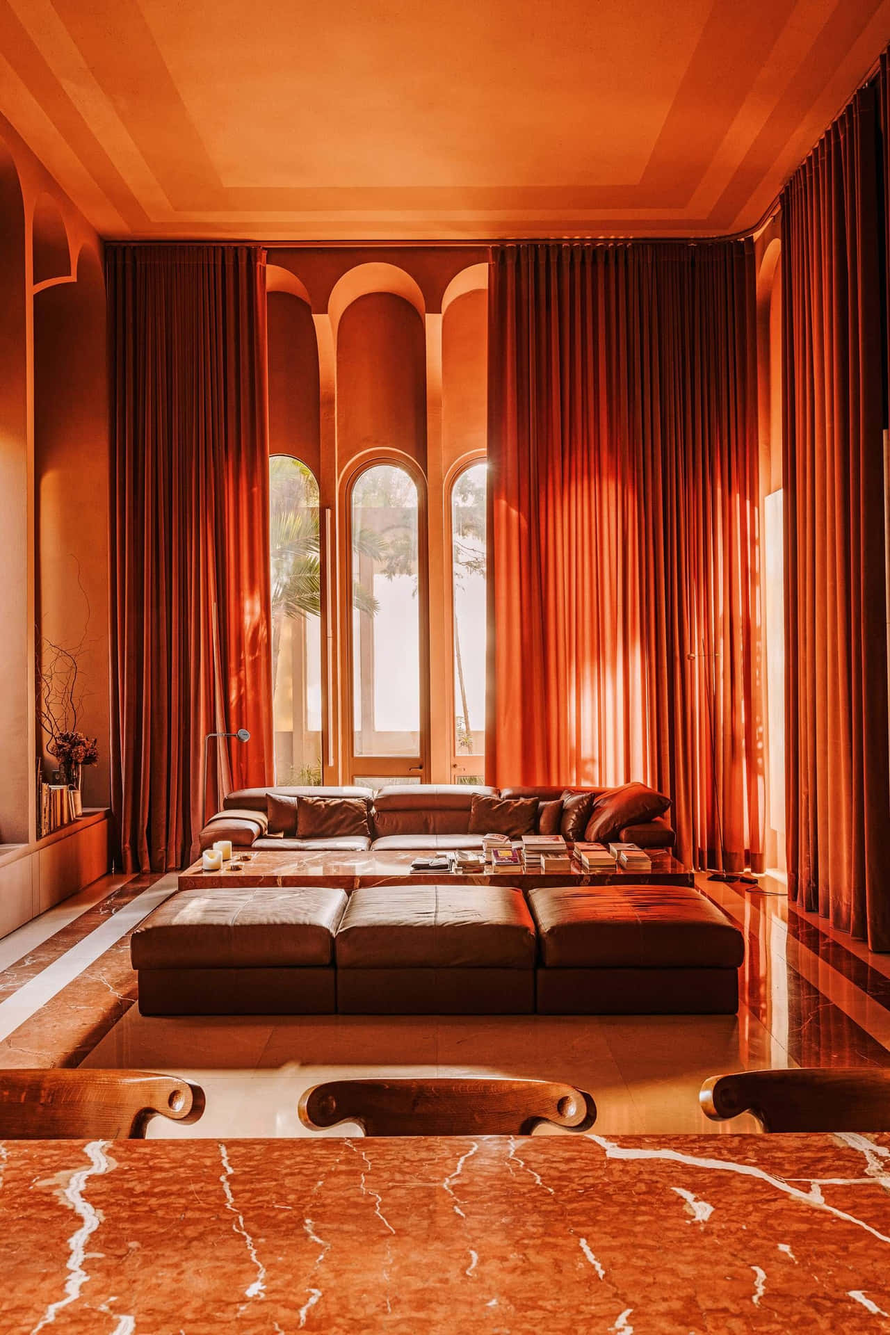 A Living Room With Orange Walls And A Marble Table