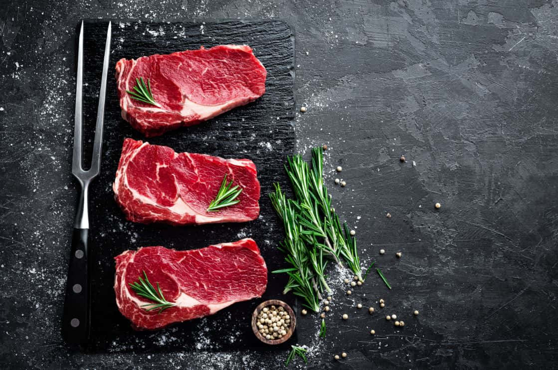 Juicy and Delicious Red Meat on a Wooden Table Wallpaper