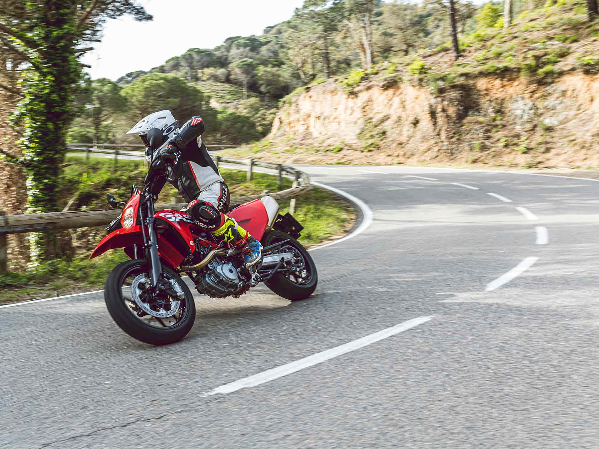 Sepeda Motor Merah Melaju Di Jalan Berbelok Wallpaper