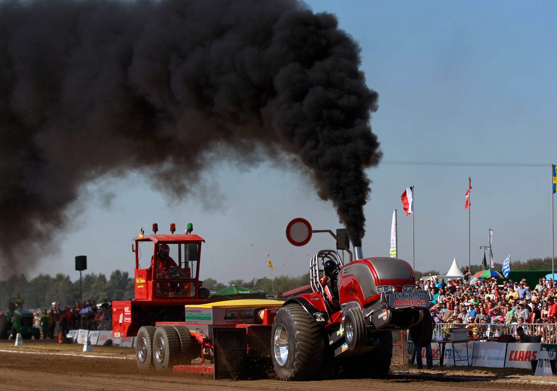 Rød trækkende traktor med sort røg Wallpaper