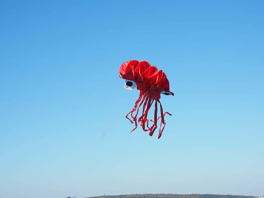 Red Squid Kite Against Blue Sky Wallpaper