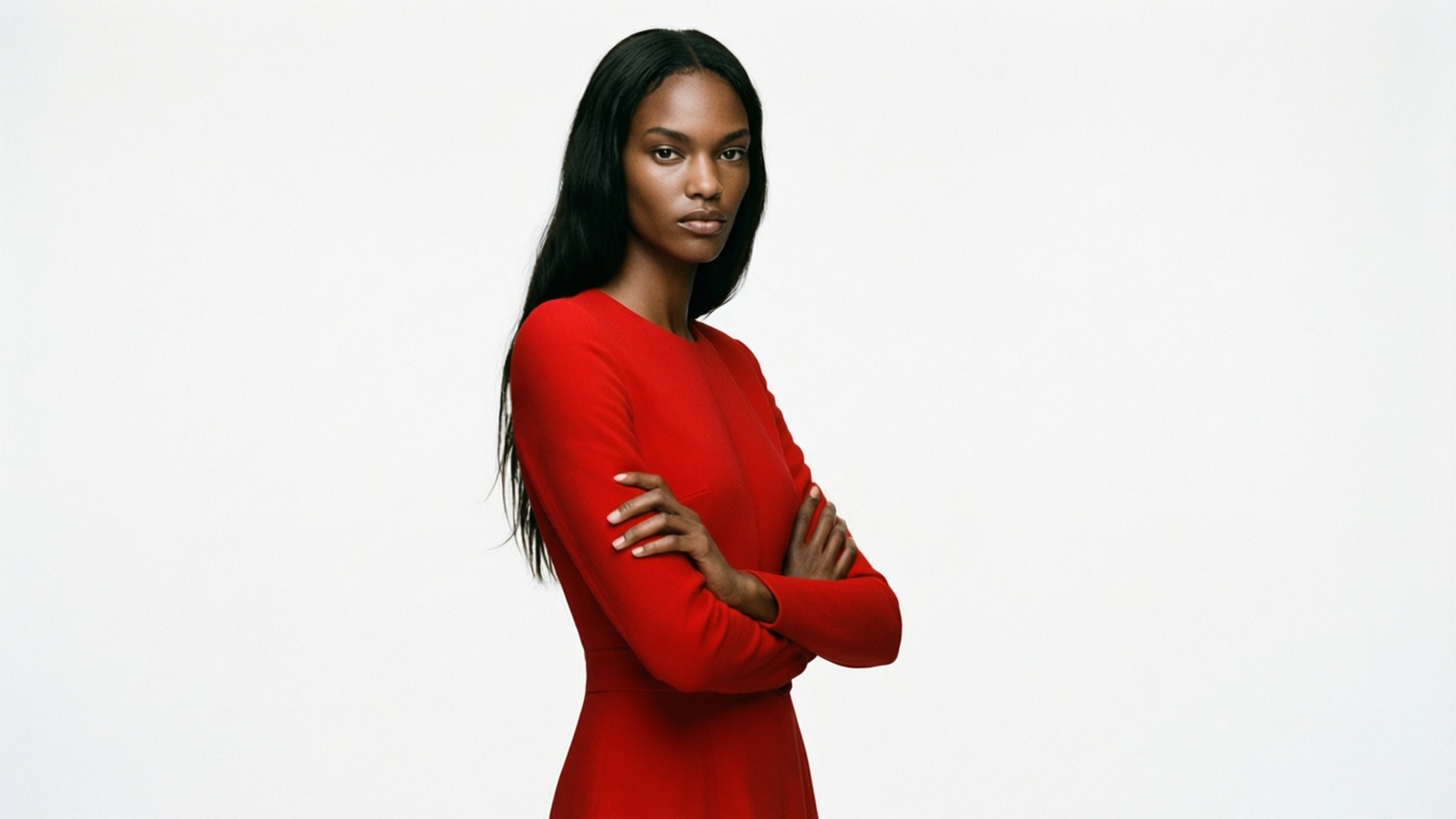 Bold studio portrait of Joan Smalls in a red dress, minimalist background, editorial style.