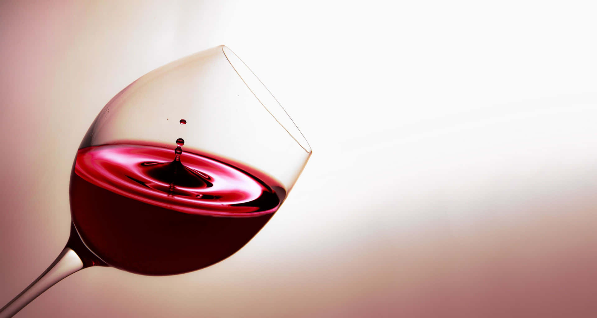 Elegant Red Wine Glass on a Wooden Table Wallpaper