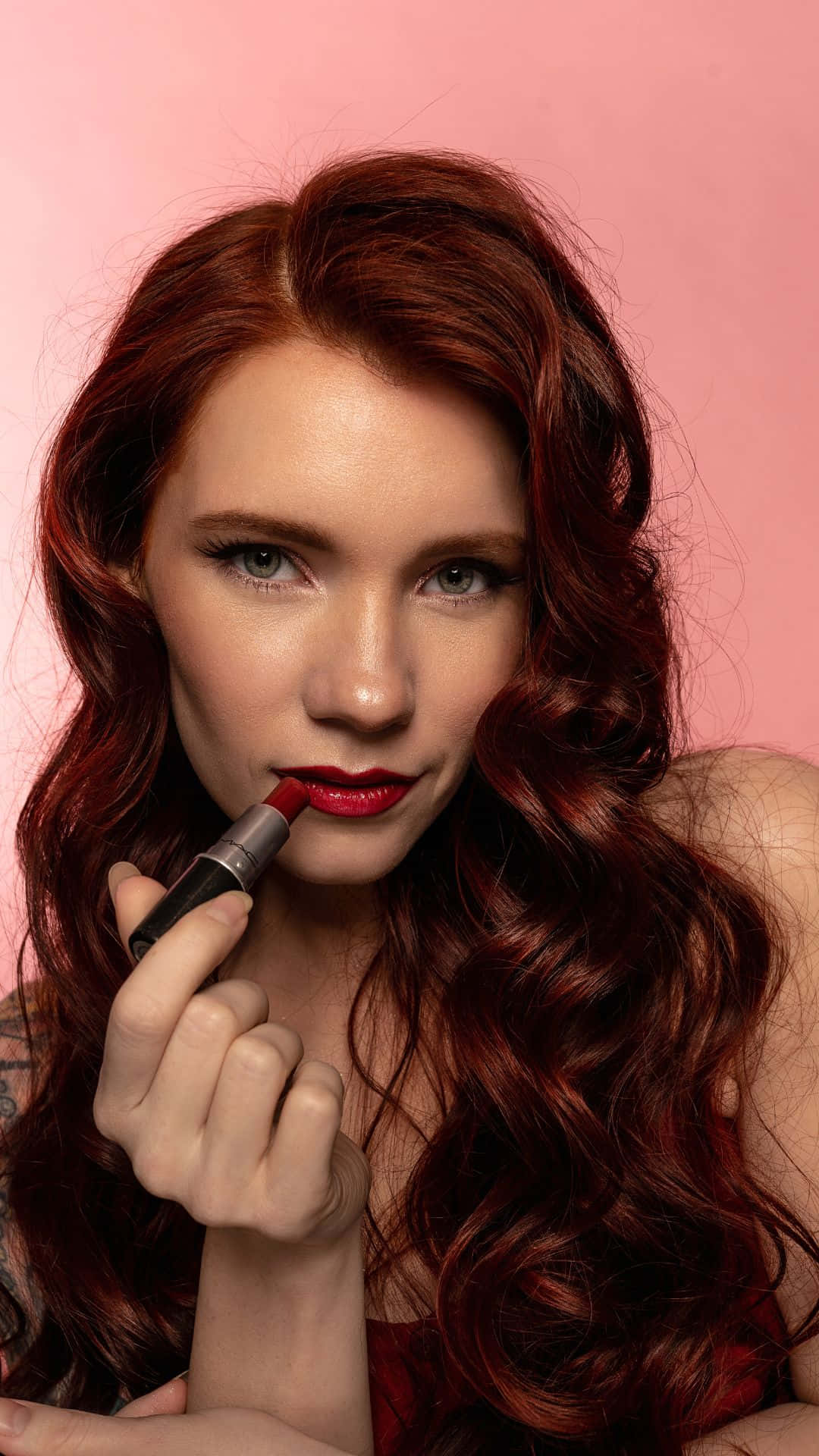 Redhead Applying Lipstick Aesthetic Wallpaper