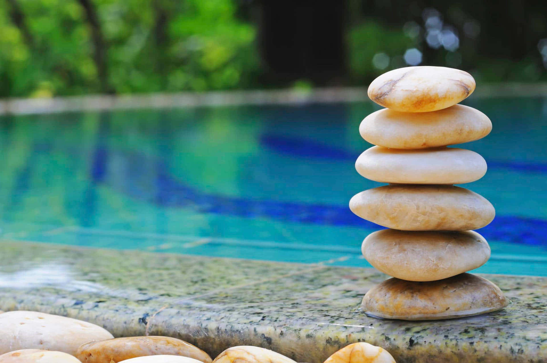 A Stack Of Stones Next To A Swimming Pool