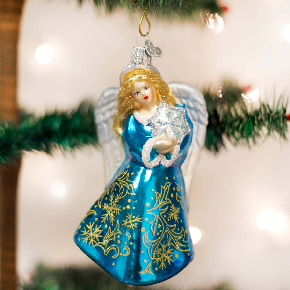 A Blue Glass Angel Ornament Hanging From A Tree