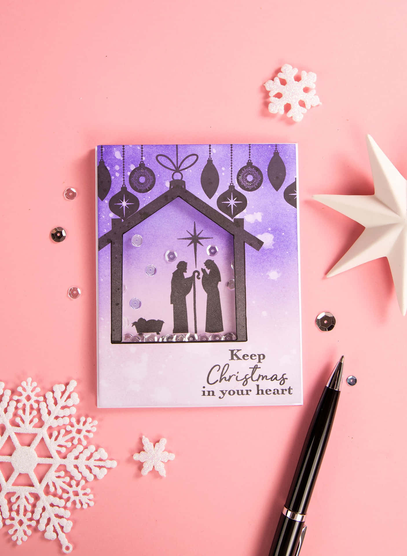 A Christmas Card With A Nativity Scene And A Pen