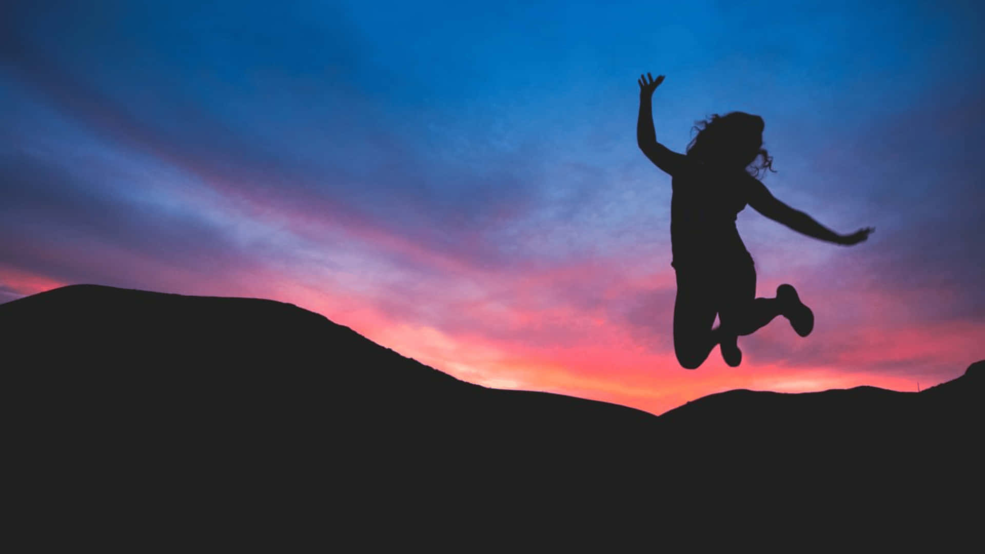 Resilient Woman Jumping In Joy Wallpaper