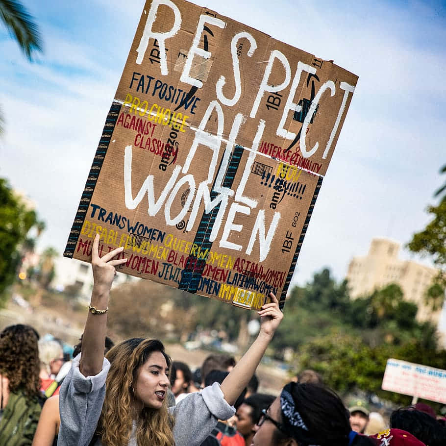 A Woman Holding Up A Sign That Says Respect All Women