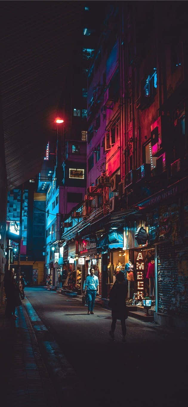 A City Street At Night With Neon Lights Wallpaper