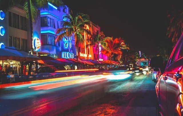 A Street Scene With Neon Lights And Palm Trees Wallpaper